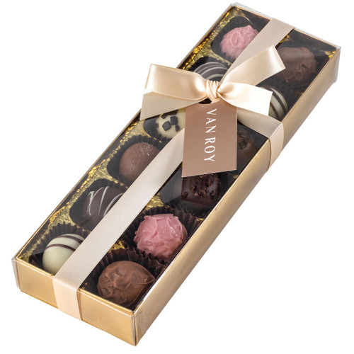 Luxury Van Roy chocolate assortment presented in a gold gift box with a satin cream ribbon and tag, containing an elegant selection of milk, dark, white and pink truffles.