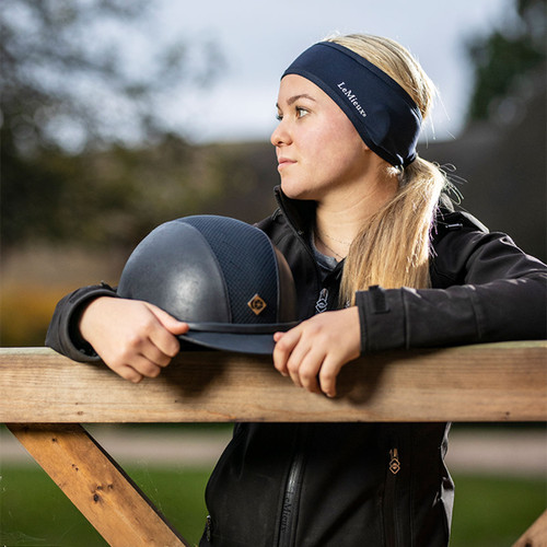 Woman leaning on a gate, wearing a indigo coloured headband