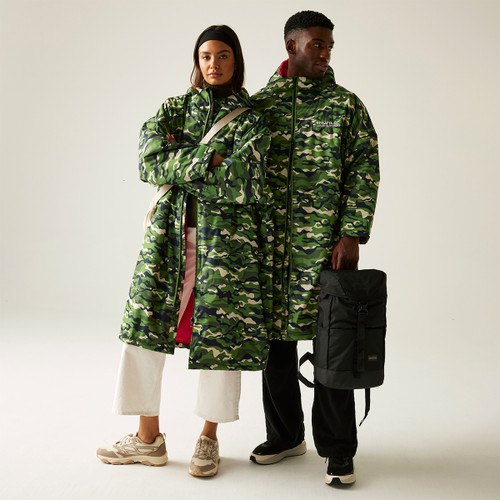 A full length view of a man and woman wearing a green camo print waterproof robe.