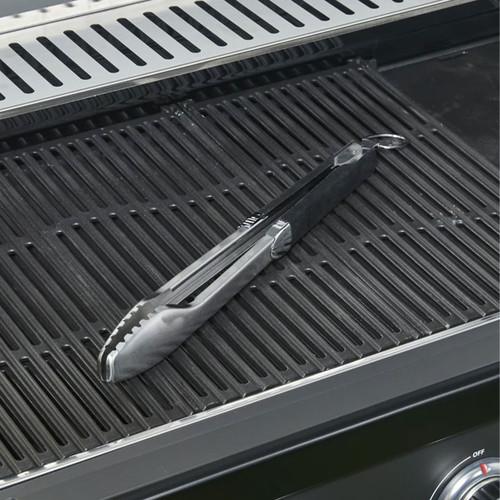 Stainless steel barbecue tongs with a black handle resting on cast iron grill grates.