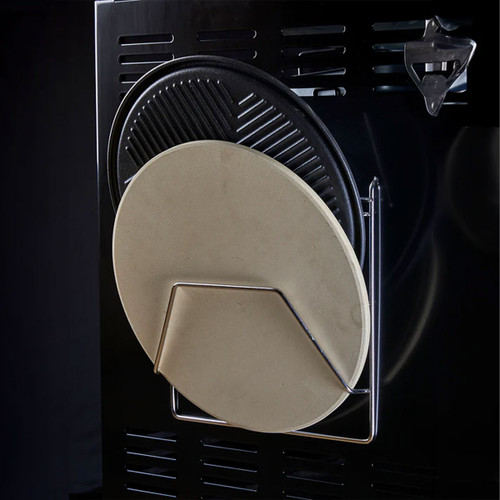 Metal storage rack holding a round pizza stone and ribbed griddle plate on the side of a barbecue.