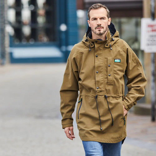 Person wearing a brown jacket with a hood and blue jeans walking on a street. Person wearing a brown jacket with a hood and blue jeans walking on a street.