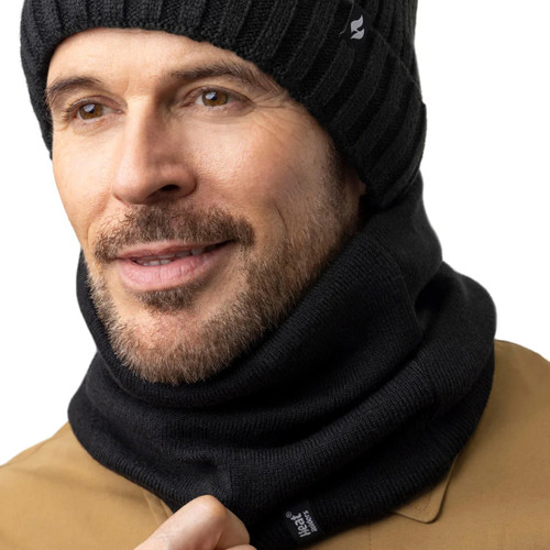A man wearing a black neck warmer with a black hat.