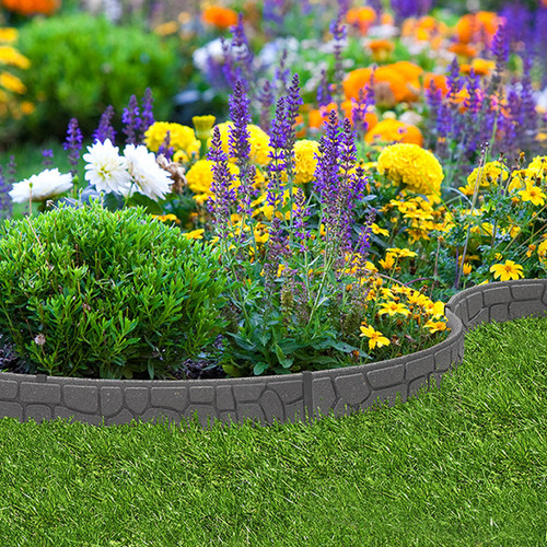 A vibrant garden with lush green grass, bordered by blooming flowers in purple, white, and yellow, conveys a cheerful and lively atmosphere.