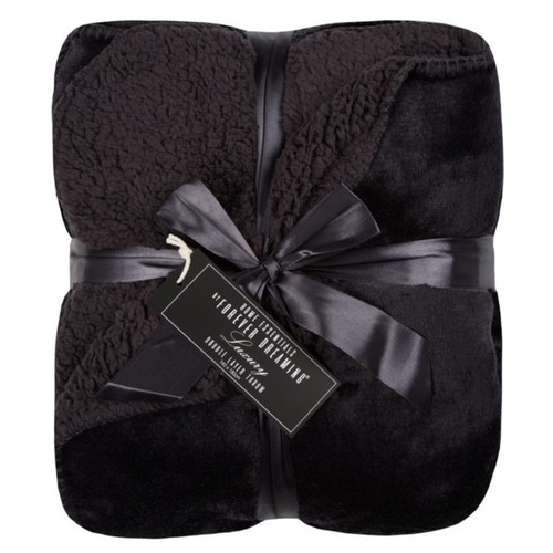 A black fluffy blanket folded and finished with a matching bow on a white background