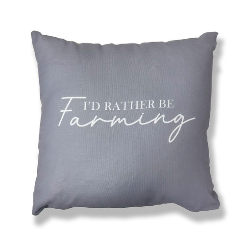 A grey cushion with the wording "I'd rather be farming" written in white on a white background