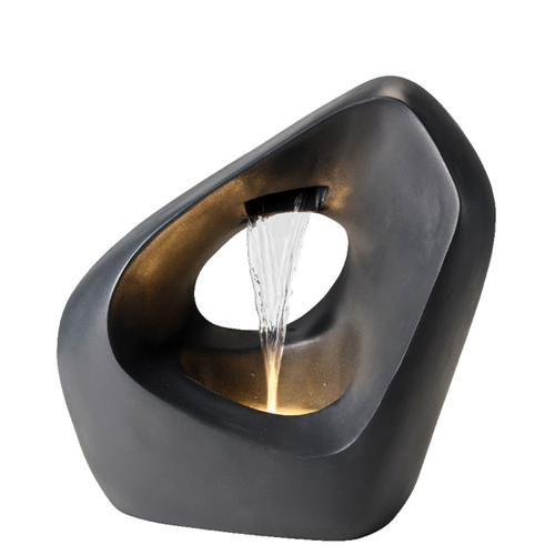 A modern, triangular black fountain with a central void, water cascading down, and warm lighting inside, creating a serene, artistic ambiance.