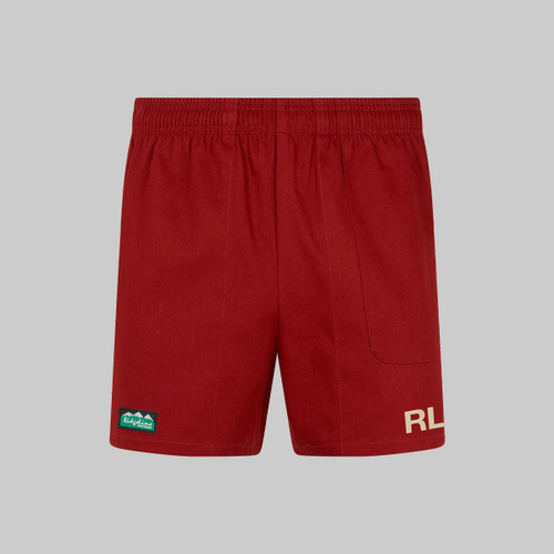 Red shorts with a logo on the left hem and a brand initials on the right.