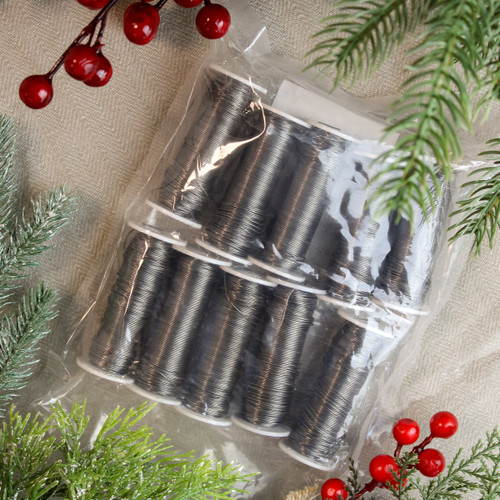 Black floral stem wire reels in retail packaging with festive greenery and red berries, ideal for wreath making, floral arranging and Christmas craft projects.