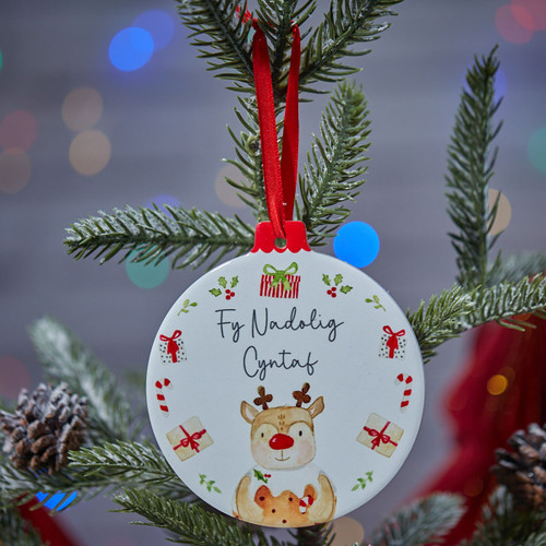 Ceramic 'Fy Nadolig Cyntaf' Christmas Hanging Decoration hanging off a tree