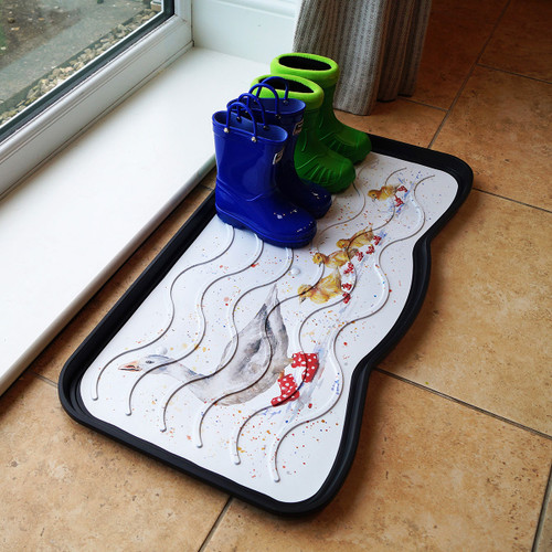 Blue and green boots on a decorative boot tray with autumn leaf patterns, placed on a tiled floor near a window. The scene feels cosy and organized.