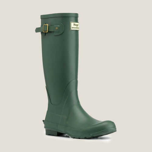 Green rubber wellington boot with adjustable strap and logo on the shaft isolated on a white background.