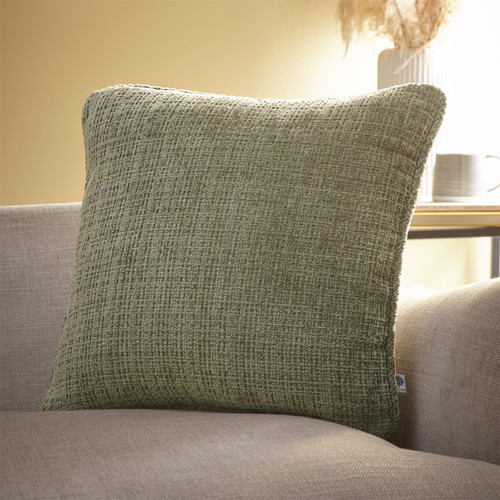 A green coloured cushion on a sofa