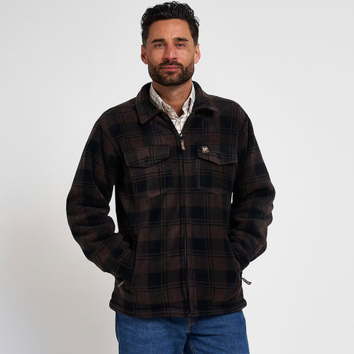 Man wearing a dark brown and black checked fleece overshirt with blue jeans, front view with hands in pockets.