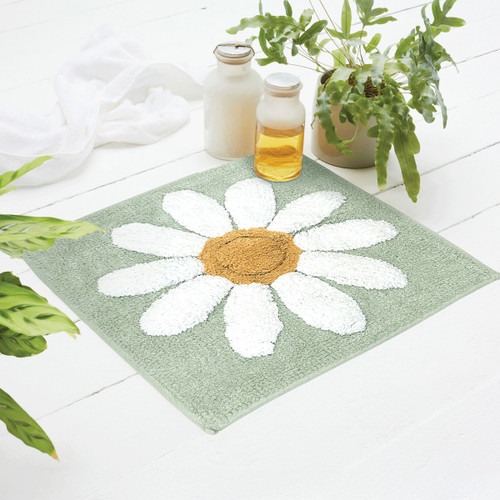 A teal shower mat with a flower.