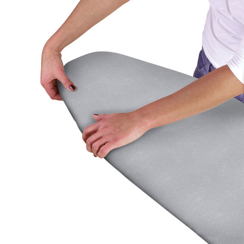A women holding a grey ironing board cover.