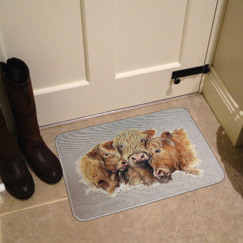 A doormat with three Highland cows is placed near a white door on a tiled floor, beside two black boots. The atmosphere is cosy and rustic.