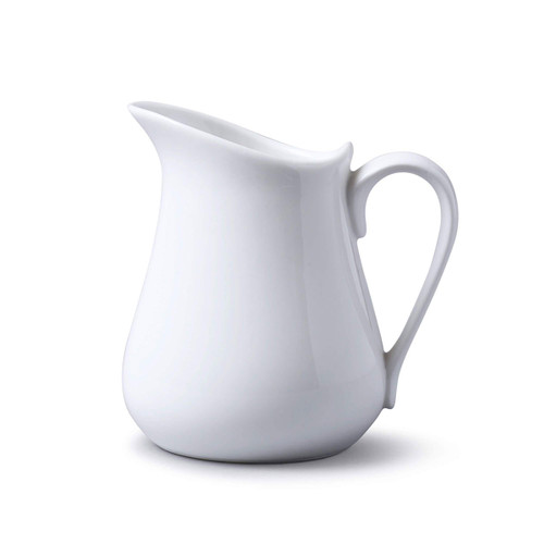 White porcelain milk jug with a handle on a white background.