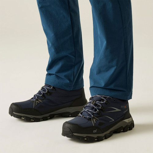Navy walking shoes with lace-up fastening and rugged black and grey grip soles, worn with blue outdoor trousers.
