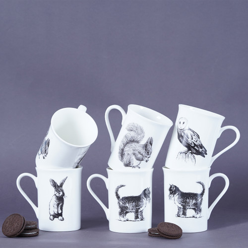 Six stacked white mugs with animal illustrations on a purple background, flanked by cookies.