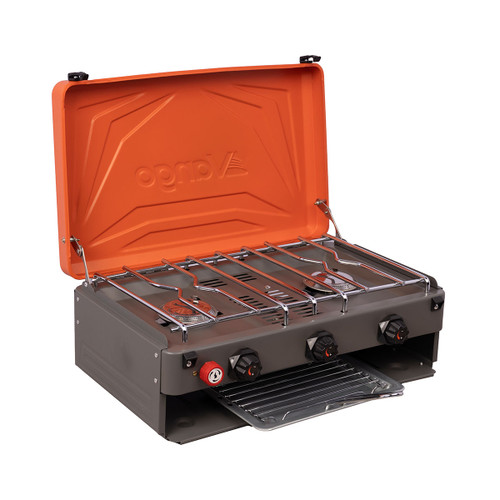 Orange-lidded camping stove with three burners, featuring black knobs and a pull-out drip tray. The design is sleek and utilitarian.