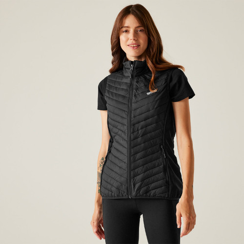 A woman wearing a black quilted gilet over a short-sleeved t-shirt.
