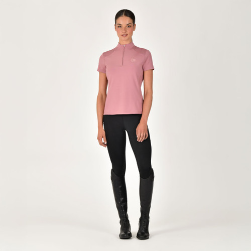 Person in a pink base layer riding top, black leggings, and tall black boots.
