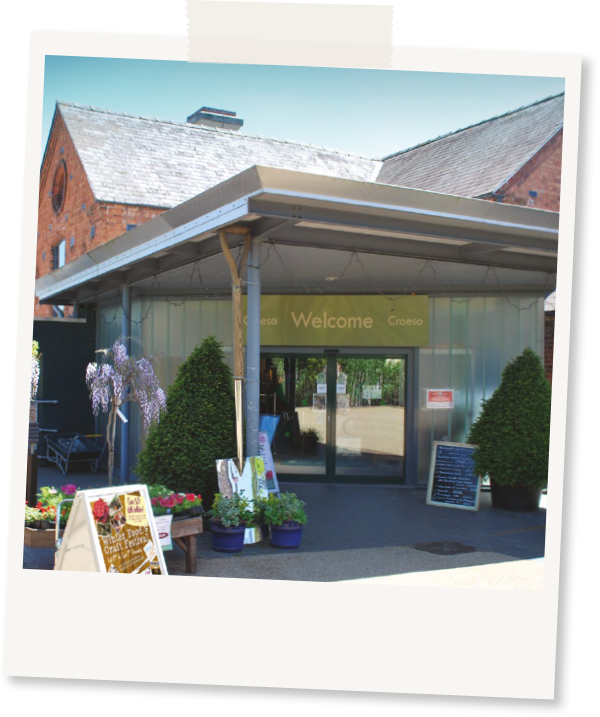 Polaroid design image of Coed-y-Dinas front entrance on a sunny day 