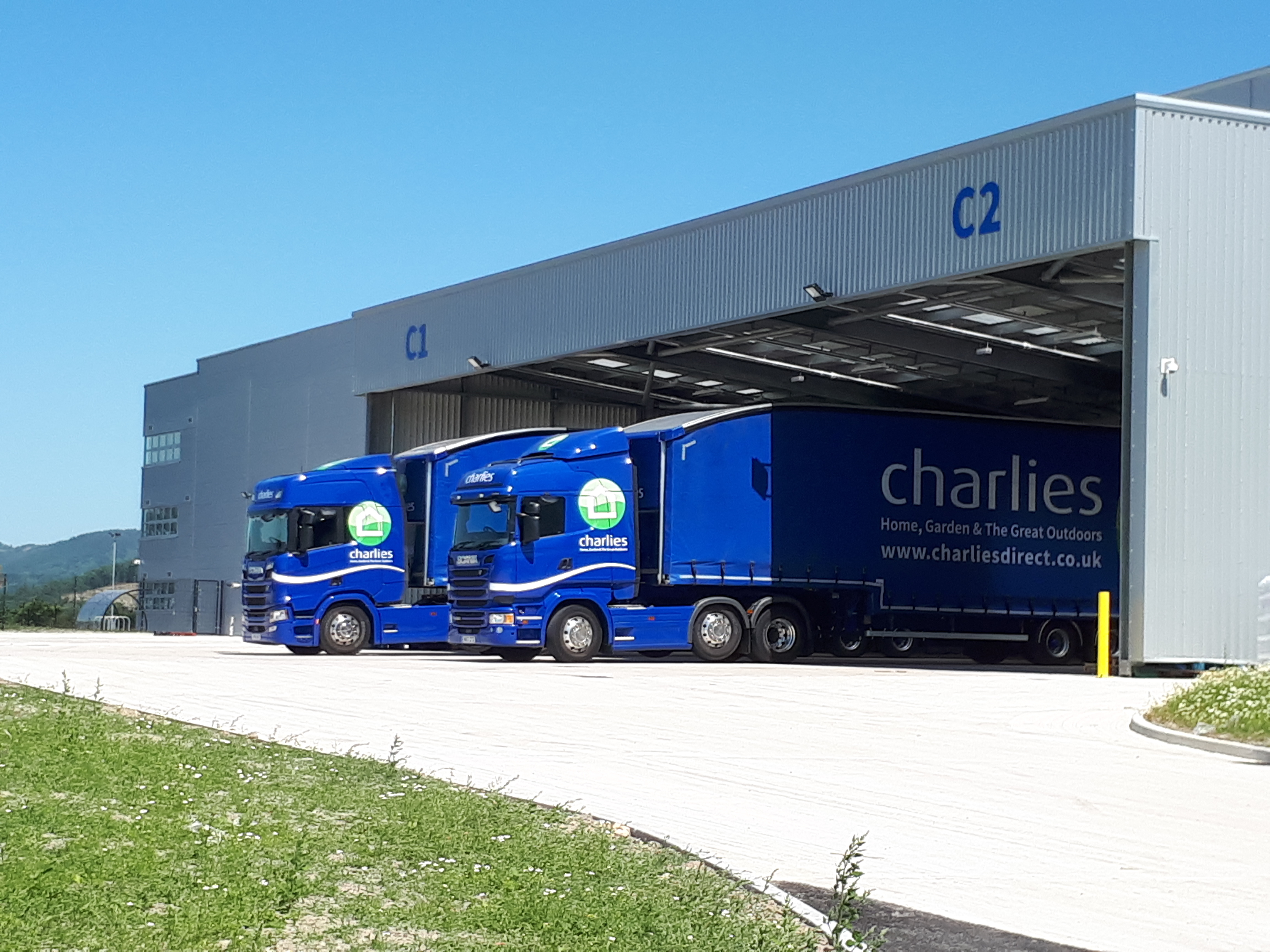 A view of two blue Charlies lorries outside the Charlies warehouse