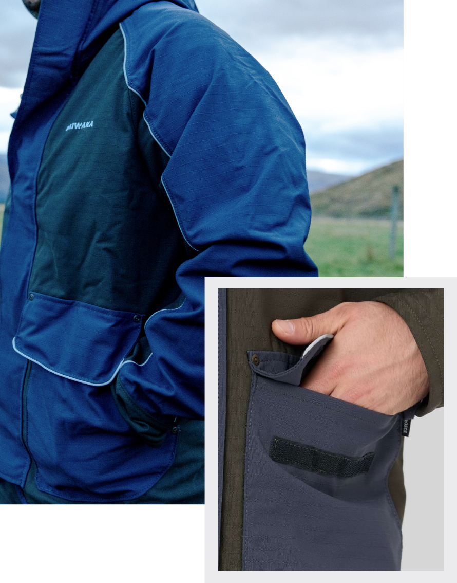Person wearing a blue jacket with front pockets in a grassy field with mountains in the background. Inset shows a hand reaching into a pocket.