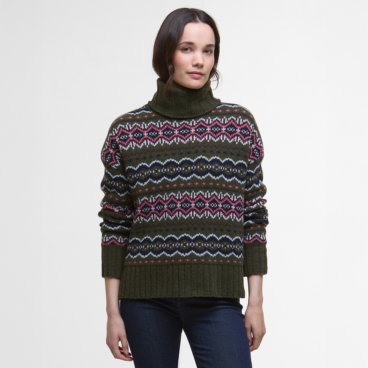 A woman wearing a dark green Barbour jumper with a fair isle design.