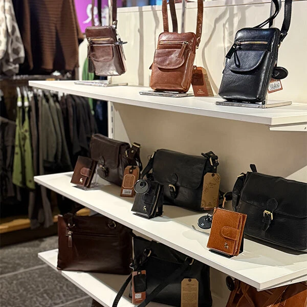 Shelves holding a range of black and brown handbags.