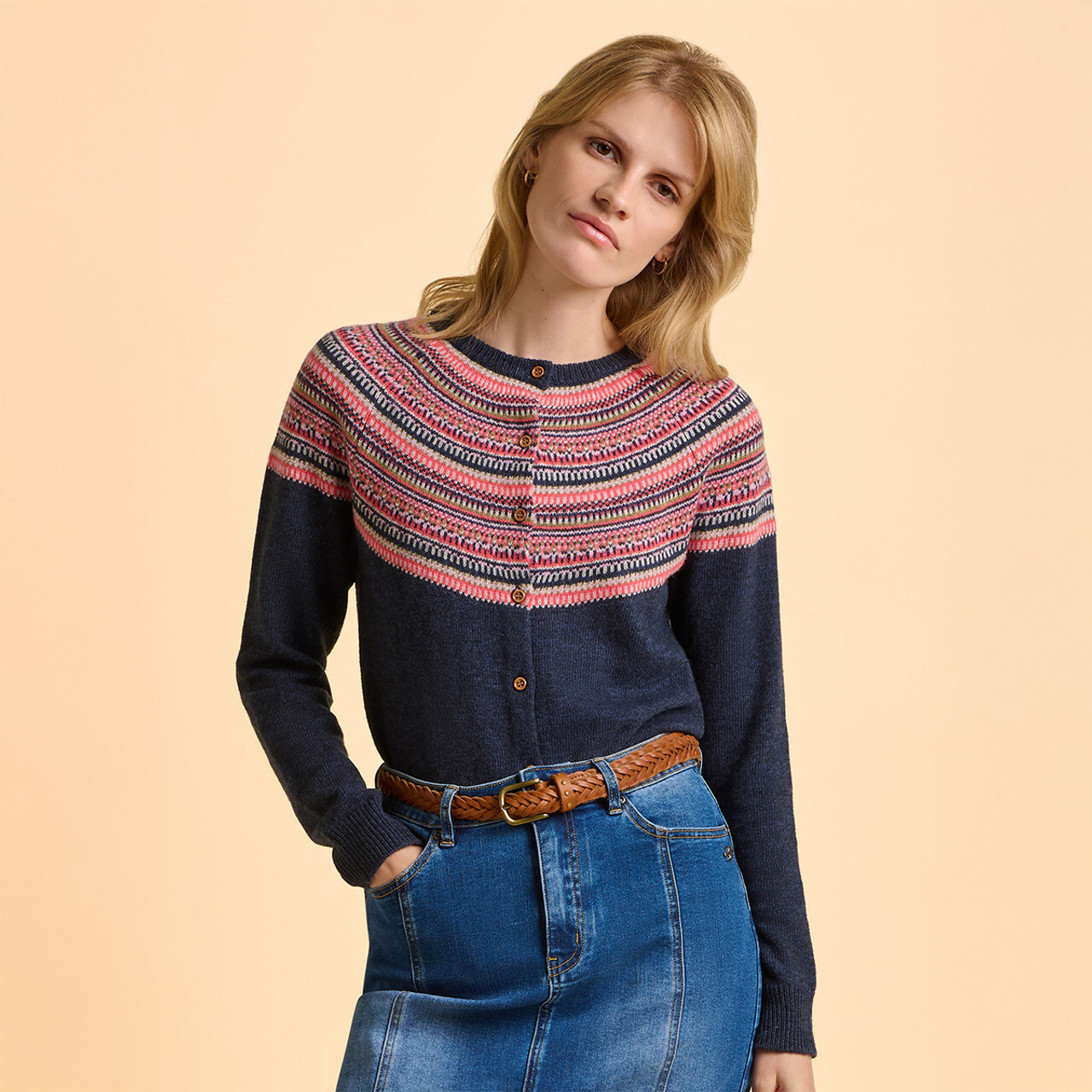 A woman wearing a navy Brakeburn cardigan with a pink fair isle print.