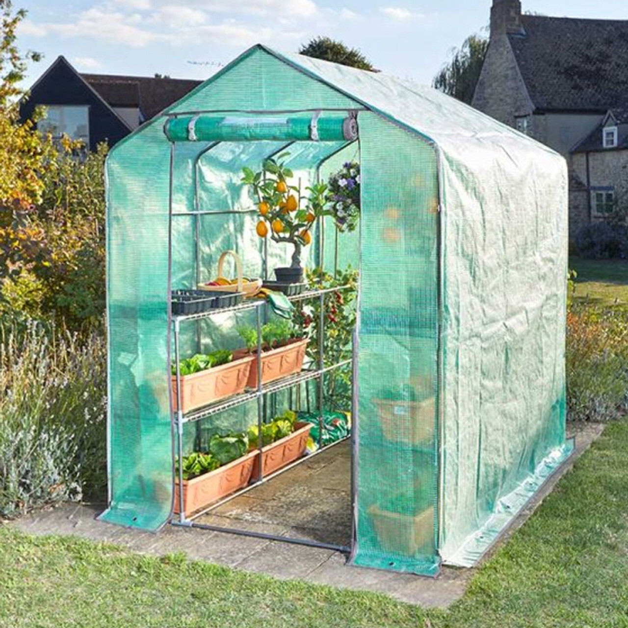 A view of a greenhouse filled with planters in a garden