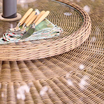 A close us of a rattan garden furniture table with a lazy susan