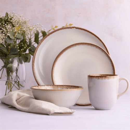 A collection of reactive glazed stoneware dinner plates, a bowl and a mug.
