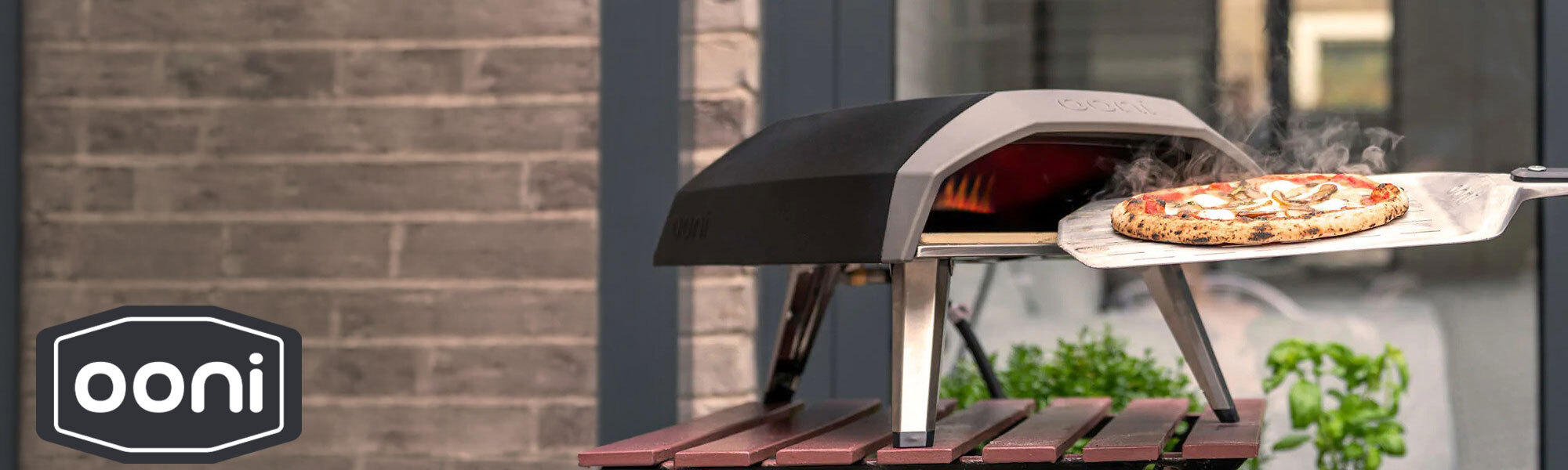 A brand banner for ooni showing a pizza oven and on ooni logo