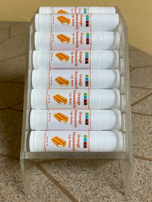 A display of tubes of Orange Dreamsicle flavored lip balms.