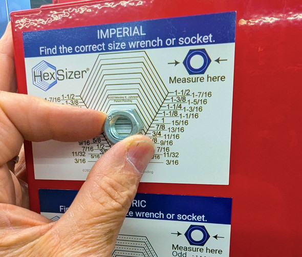 Imperial and Metric wrench size magnets on a red toolbox, sizing a nut in the V