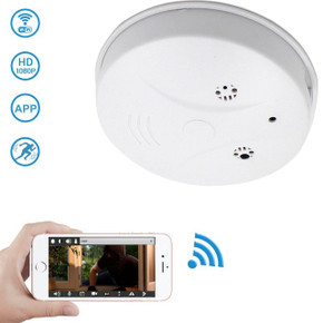 Gio Enterprises AC Power Dummy Smoke Detector WiFi, Dvr Surveillance Security Camera with Wireless Streaming Video for PC, Tablet & More, includes 4-hour battery and AC power cord, shown alongside a smartphone streaming live video.