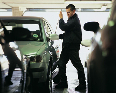 Zetta Z16, a dash camera with 10-hour battery life, HD 720p resolution, 160-degree viewing angle, and no WiFi, mounted inside a vehicle. The image shows a man inspecting the car from outside.