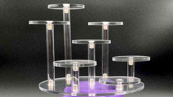 Clear acrylic stand with circular base and 7 circular platforms of varying heights.