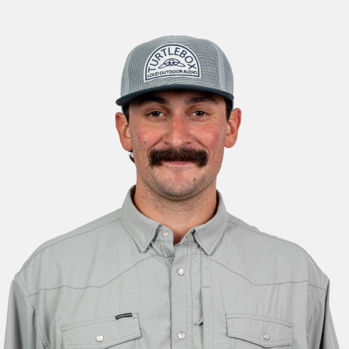 Man wearing the Turtlebox all mesh blue cap, front view showing the Turtlebox patch