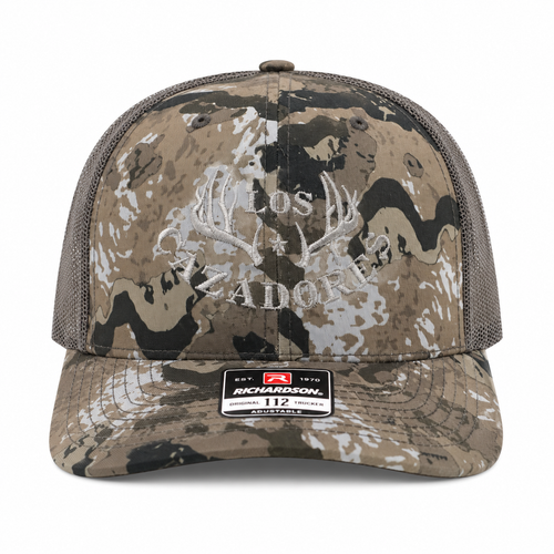 whitebox image of front view of los cazadores original horns logo in grey embroidered on cap that is caza ov camo patterned with beluga gray colored backing