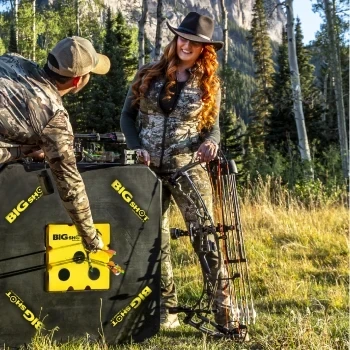 Hunters with a compound bow standing next to the BIGshot Titan archery target outdoors