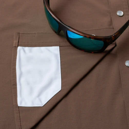 Close-up of sunglasses in the sunglasses holder and the built-in lens cloth on The Lewis Poncho Tuff-Thread shirt
