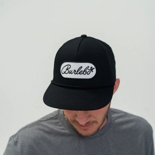 Man wearing the black Burlebo oval script cap with a white oval Burlebo script patch