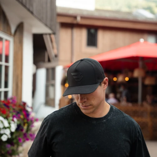 Man wearing the Burlebo black Flying B performance cap outside a restaurant