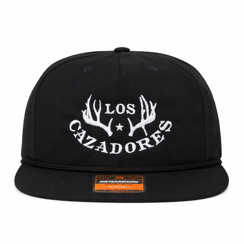 Front view of a black Los Cazadores rope hat with white embroidered logo and flat brim on a white background.