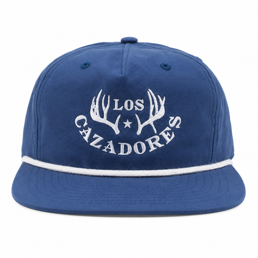 Front view of a blue Los Cazadores rope hat with white embroidered logo and white rope detail on white.